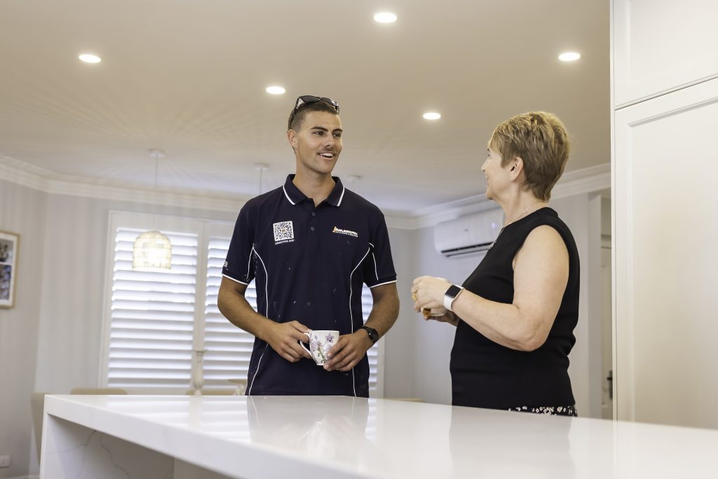 Smartfix electrician sharing a friendly cup of tea with an older Perth homeowner after completing electrical work. Respectful service built on trust and genuine connection.