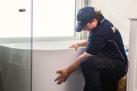 Plumber installing new bath tub