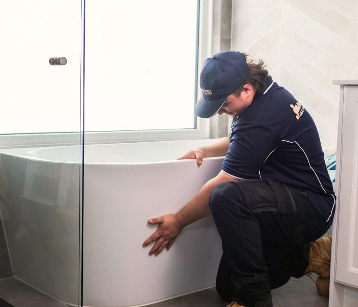 Plumber installing new bath tub